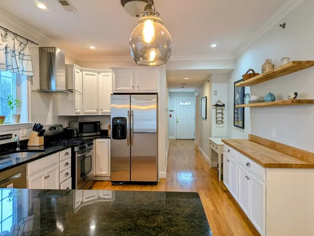 a kitchen with stainless steel appliances granite countertop a sink a stove and a refrigerator