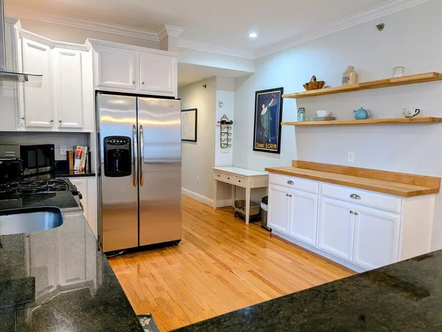 a kitchen with stainless steel appliances granite countertop a refrigerator a stove and a sink