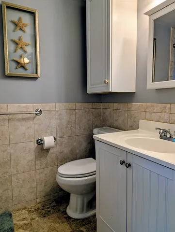 a bathroom with a toilet sink and mirror