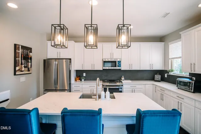 a kitchen with stainless steel appliances kitchen island granite countertop a sink a stove and refrigerator