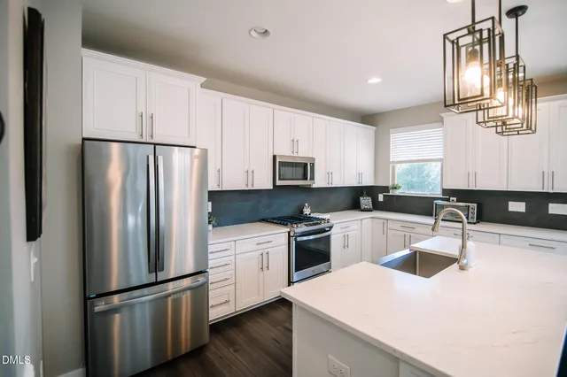 a kitchen with white cabinets and stainless steel appliances