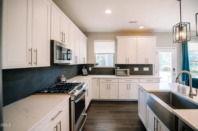 a kitchen with stainless steel appliances granite countertop a sink a stove and cabinets