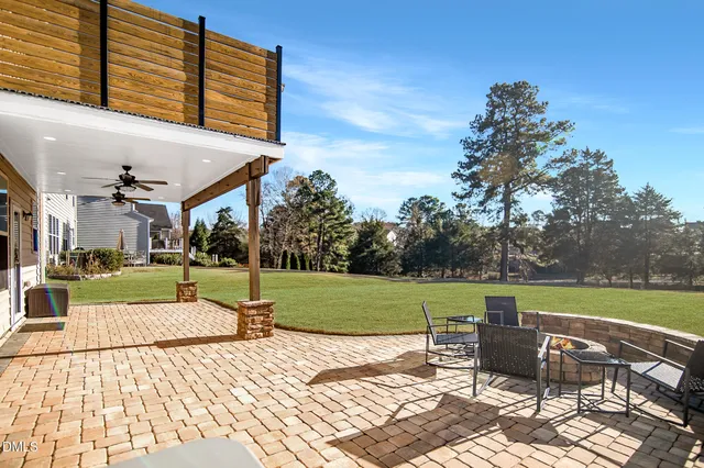 a view of a backyard with table and chairs under an umbrella