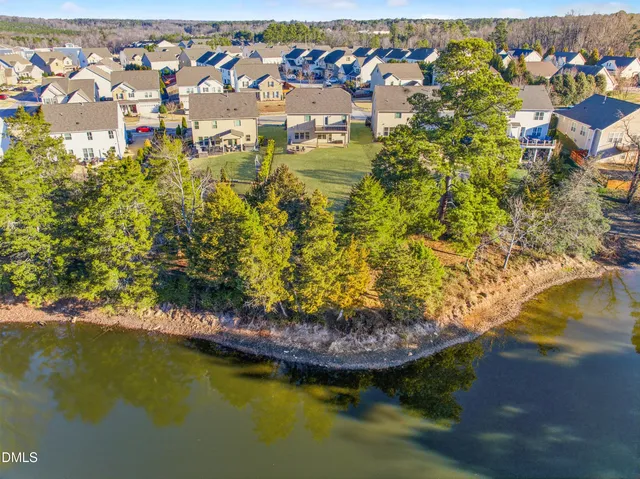 an aerial view of a house with swimming pool and lake view