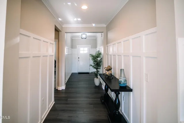 a hallway with wooden floor stairs and furniture