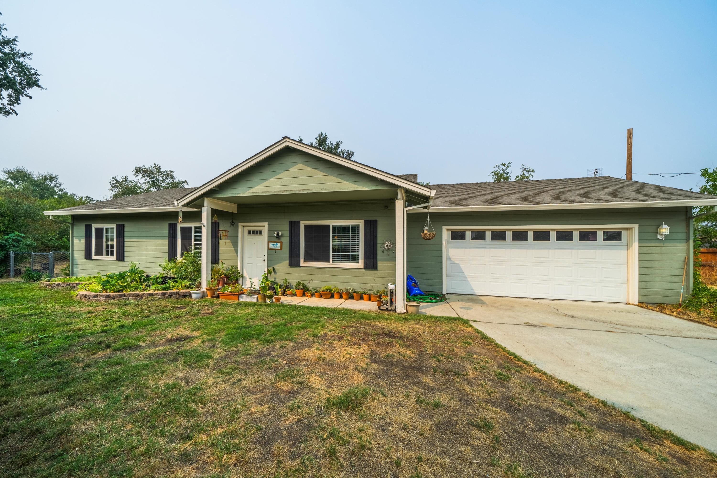 5484 Cedars Road Redding, CA 96001 - Photo 1 of 11 a front view of a house with a garden and yard