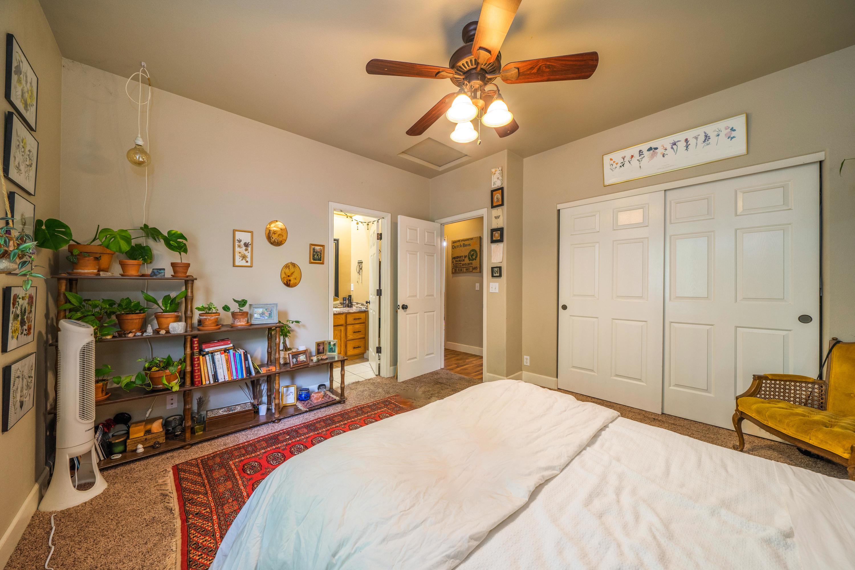 5484 Cedars Road Redding, CA 96001 - Photo 5 of 11 a bedroom with a bed a couch and a chandelier