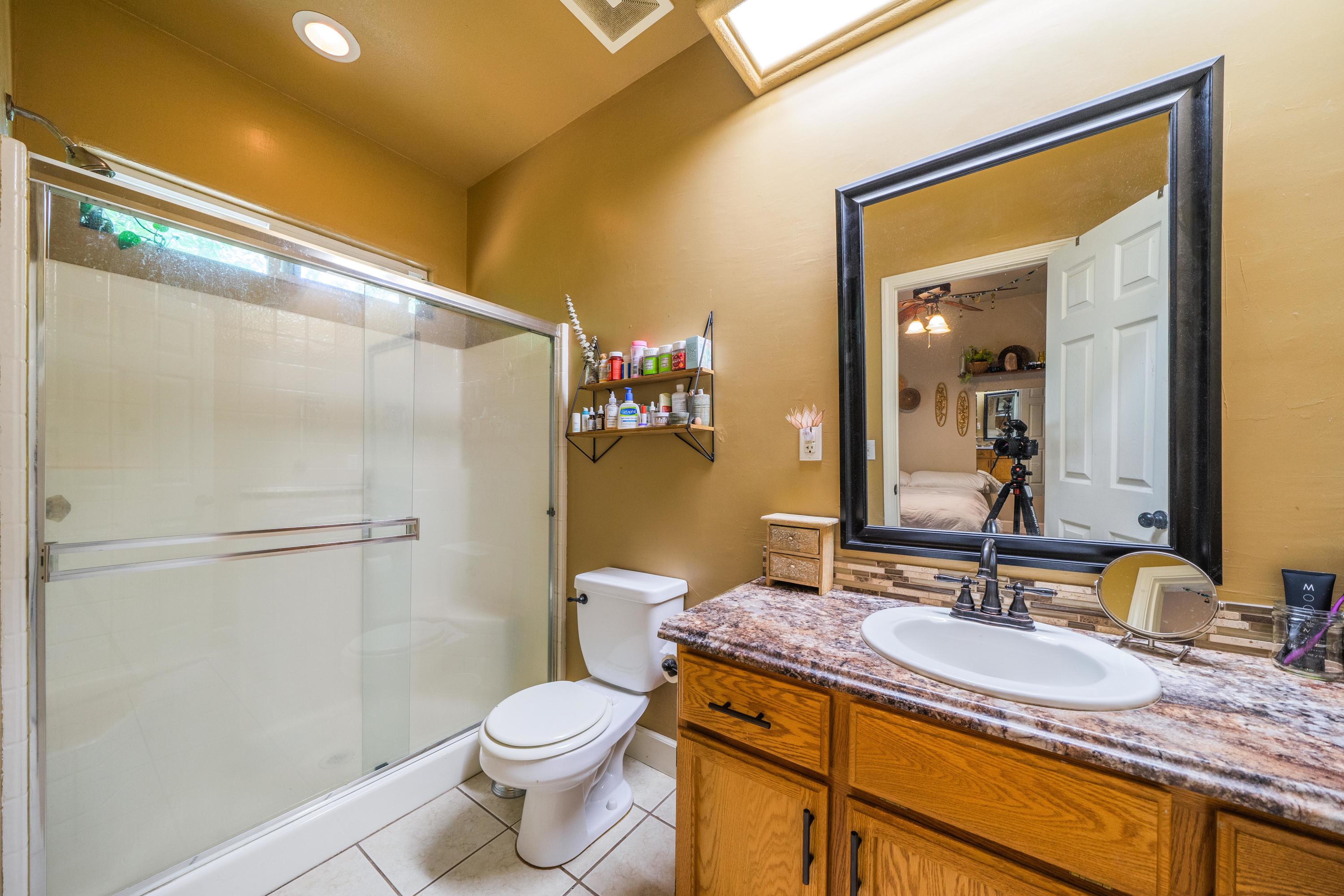 5484 Cedars Road Redding, CA 96001 - Photo 6 of 11 a bathroom with a granite countertop sink toilet and shower