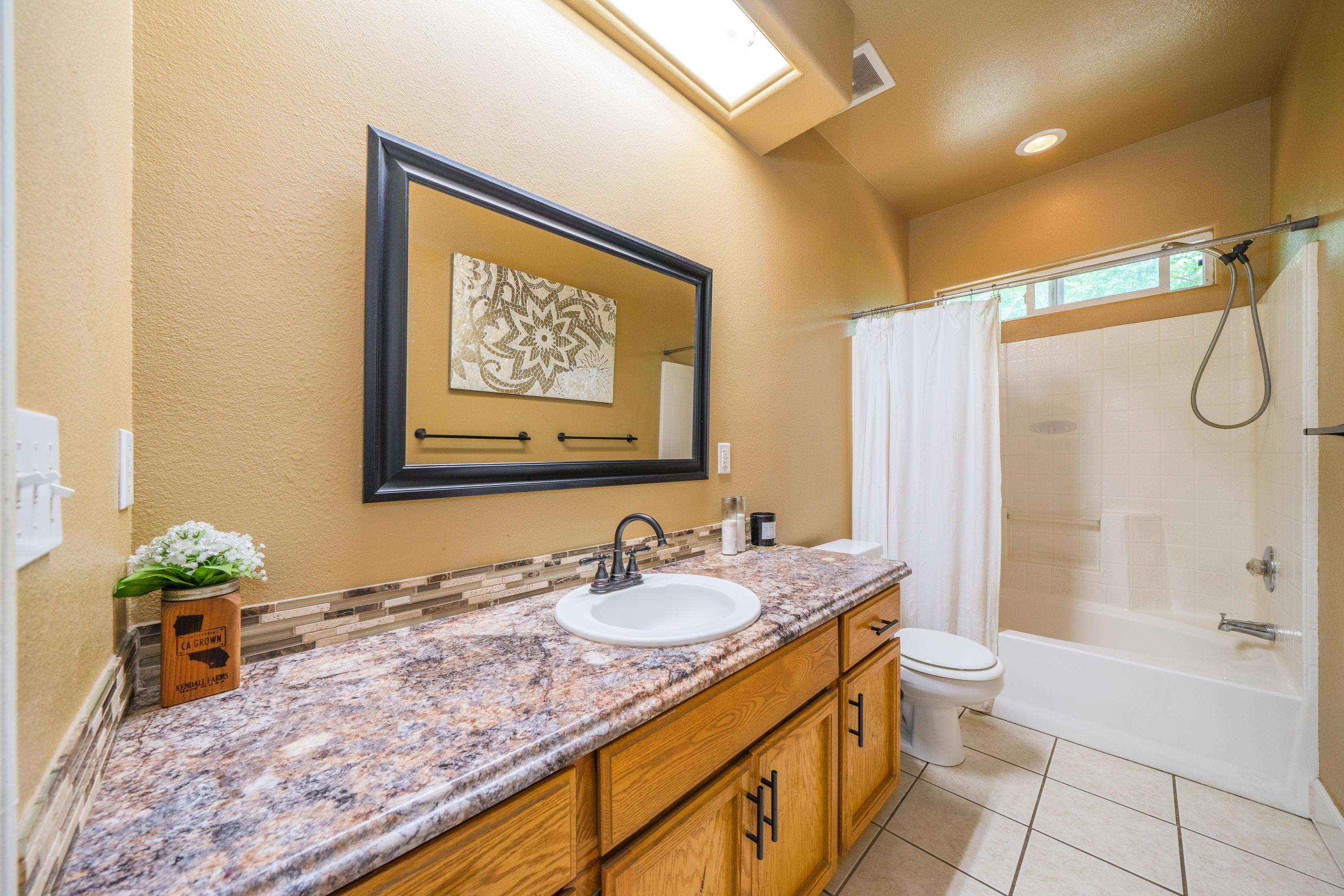 5484 Cedars Road Redding, CA 96001 - Photo 8 of 11 a bathroom with a granite countertop sink a toilet and shower