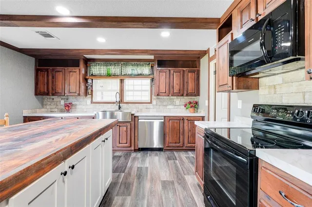 a kitchen with a sink stove top oven and cabinets