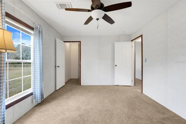 an empty room with chandelier fan