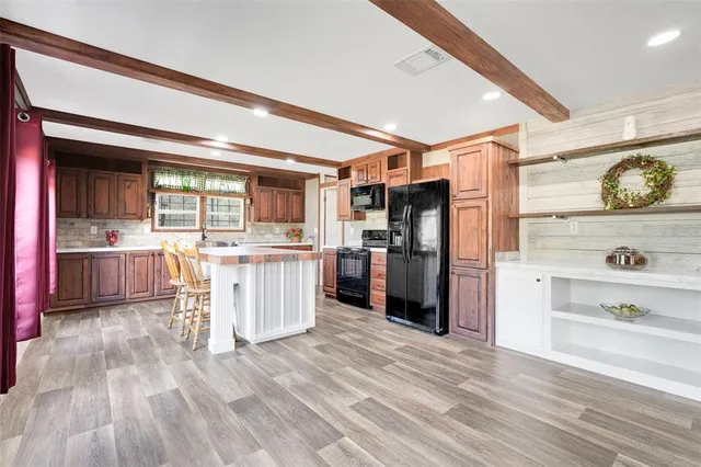 a kitchen with kitchen island white cabinets and refrigerator
