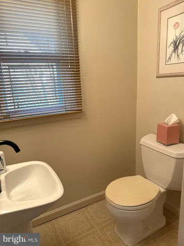 a bathroom with a toilet a sink and a window