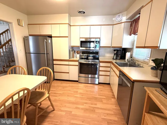 a kitchen with stainless steel appliances a refrigerator stove microwave and sink