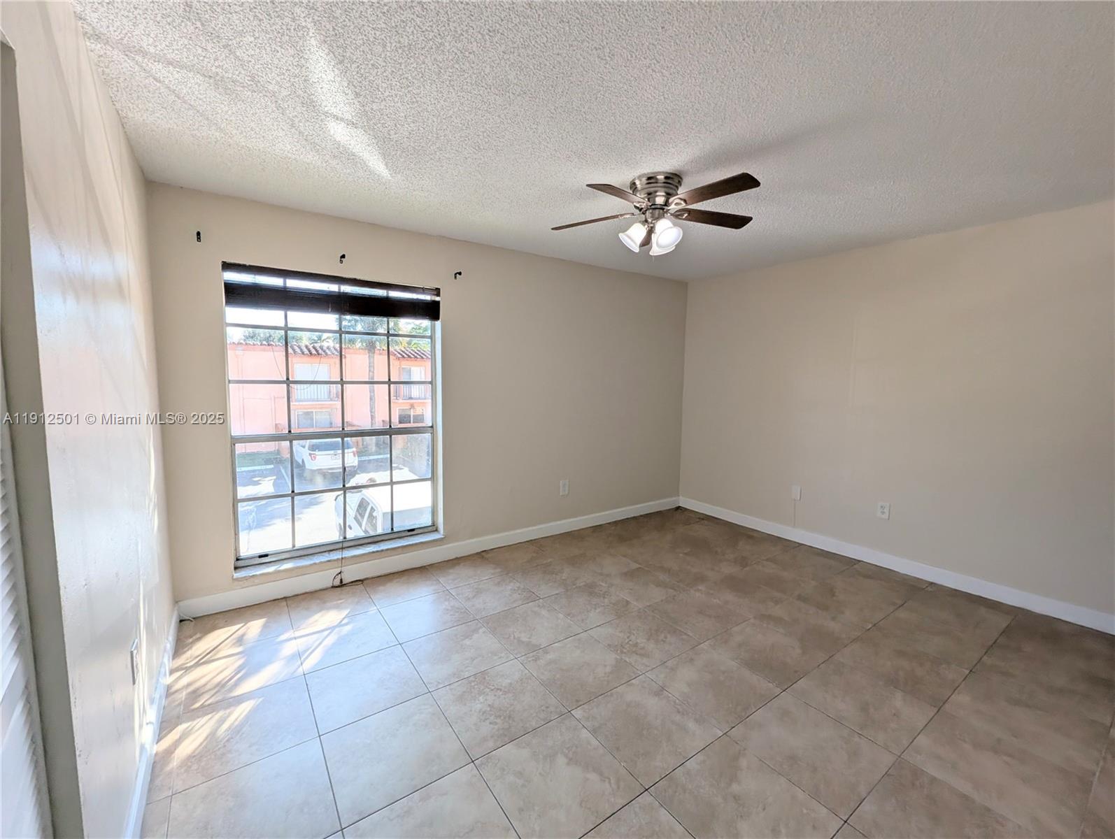 7230 Fairway Drive, Unit F4 Miami Lakes, FL 33014 - Photo 12 of 22 an empty room with chandelier fan and windows
