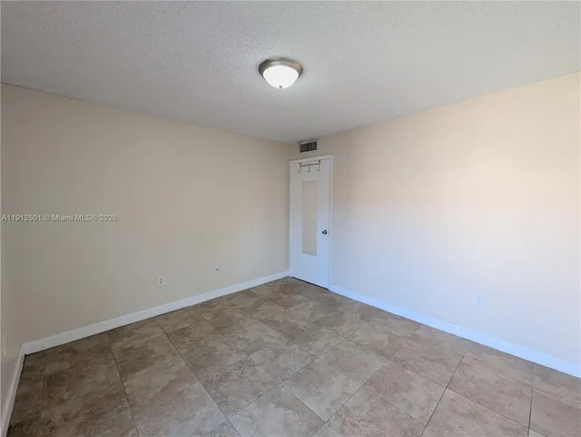 an empty room with windows and ceiling fan