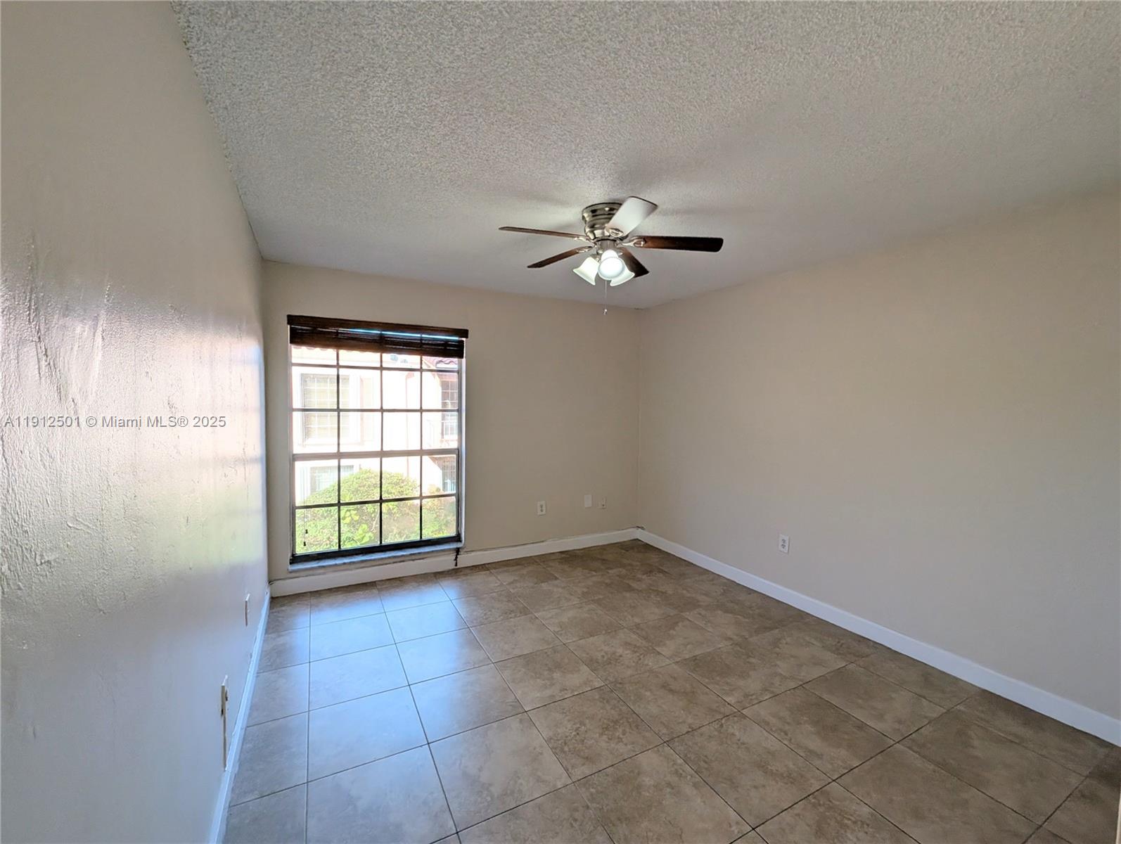 7230 Fairway Drive, Unit F4 Miami Lakes, FL 33014 - Photo 18 of 22 an empty room with windows and ceiling fan