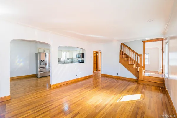 a view of an empty room with window and wooden floor