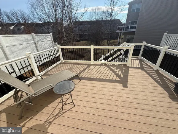a view of a roof deck with table and chairs with wooden floor