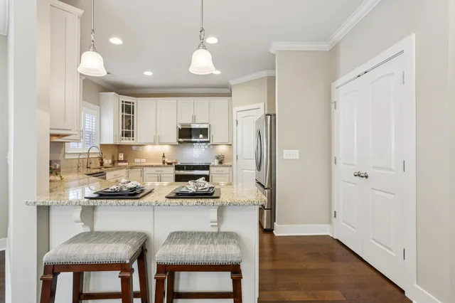 a kitchen with stainless steel appliances granite countertop a stove a sink and a refrigerator