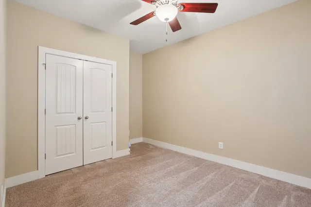 a view of an empty room with a ceiling fan