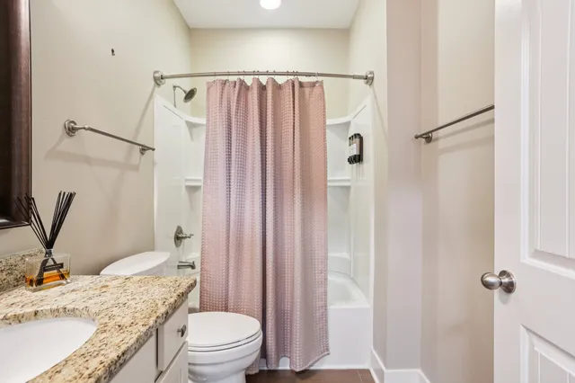 a bathroom with a toilet a sink a vanity and mirror