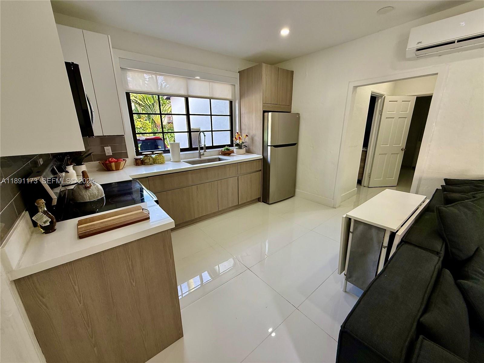 733 Michigan Avenue, Unit 9 Miami Beach, FL 33139 - Photo 4 of 13 a room with furniture a large window and wooden floor