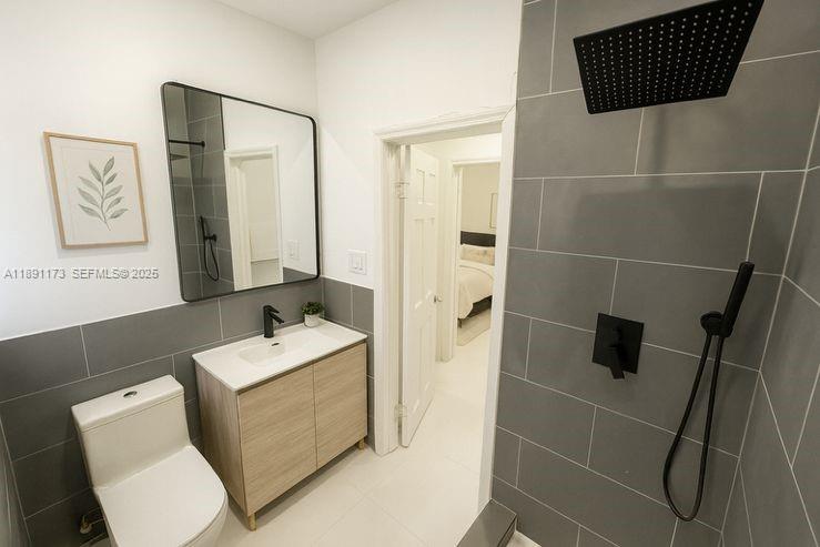 733 Michigan Avenue, Unit 9 Miami Beach, FL 33139 - Photo 7 of 13 a bathroom with a toilet a sink and glass door