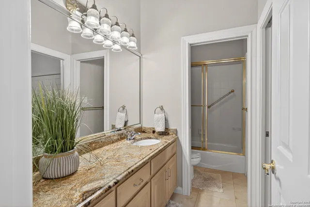 a bathroom with a granite countertop sink a mirror and a shower