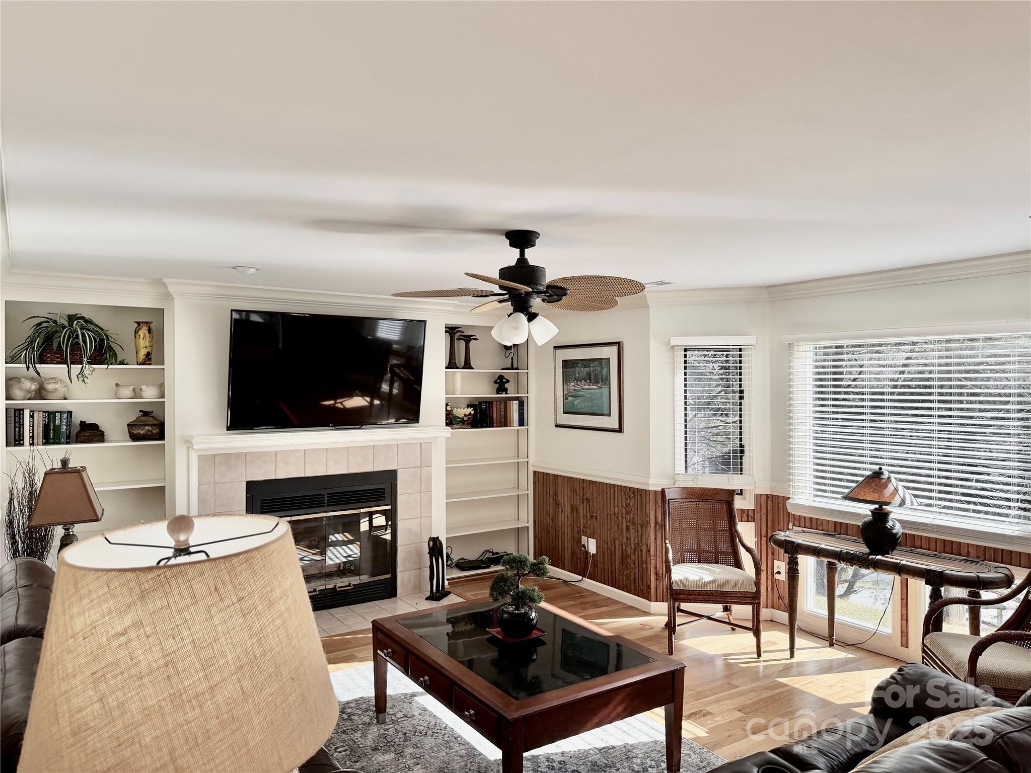 a living room with furniture a flat screen tv and a fireplace