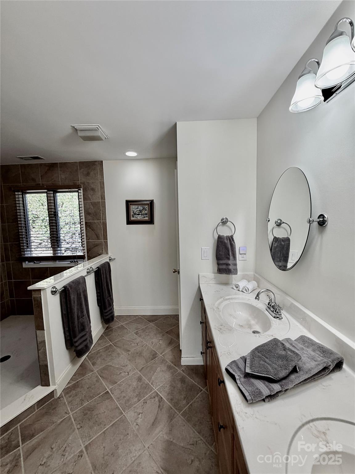 111 Burning Tree Lane, Unit C601 Flat Rock, NC 28731 - Photo 17 of 32 a bathroom with a granite countertop sink a mirror and vanity