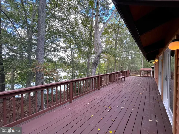 a view of house with wooden deck and furniture