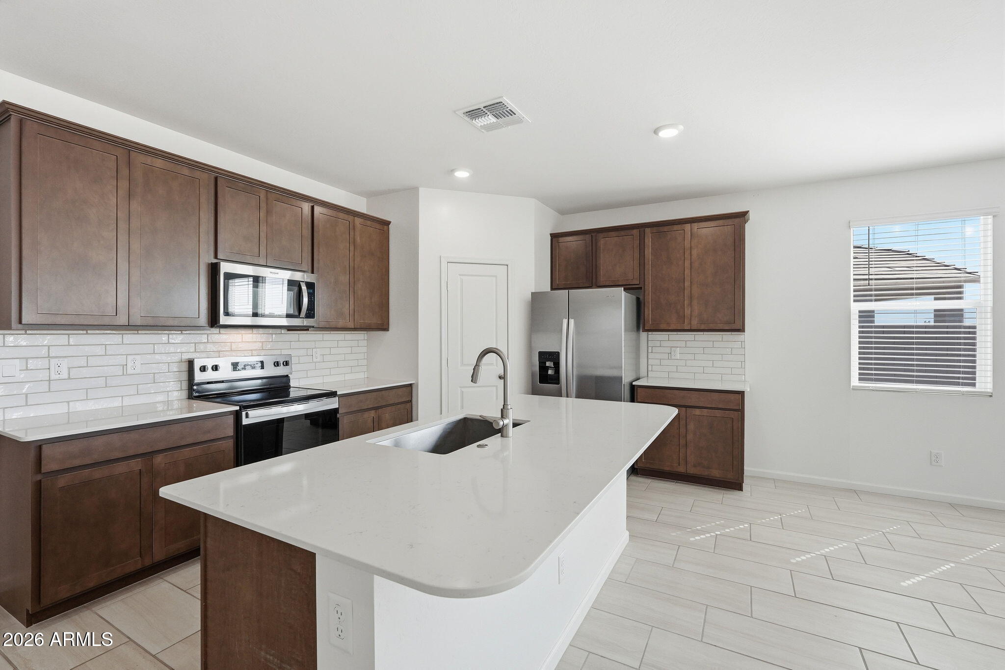25489 West Fraktur Road Buckeye, AZ 85326 - Photo 12 of 39 a kitchen with stainless steel appliances a microwave sink refrigerator and cabinets