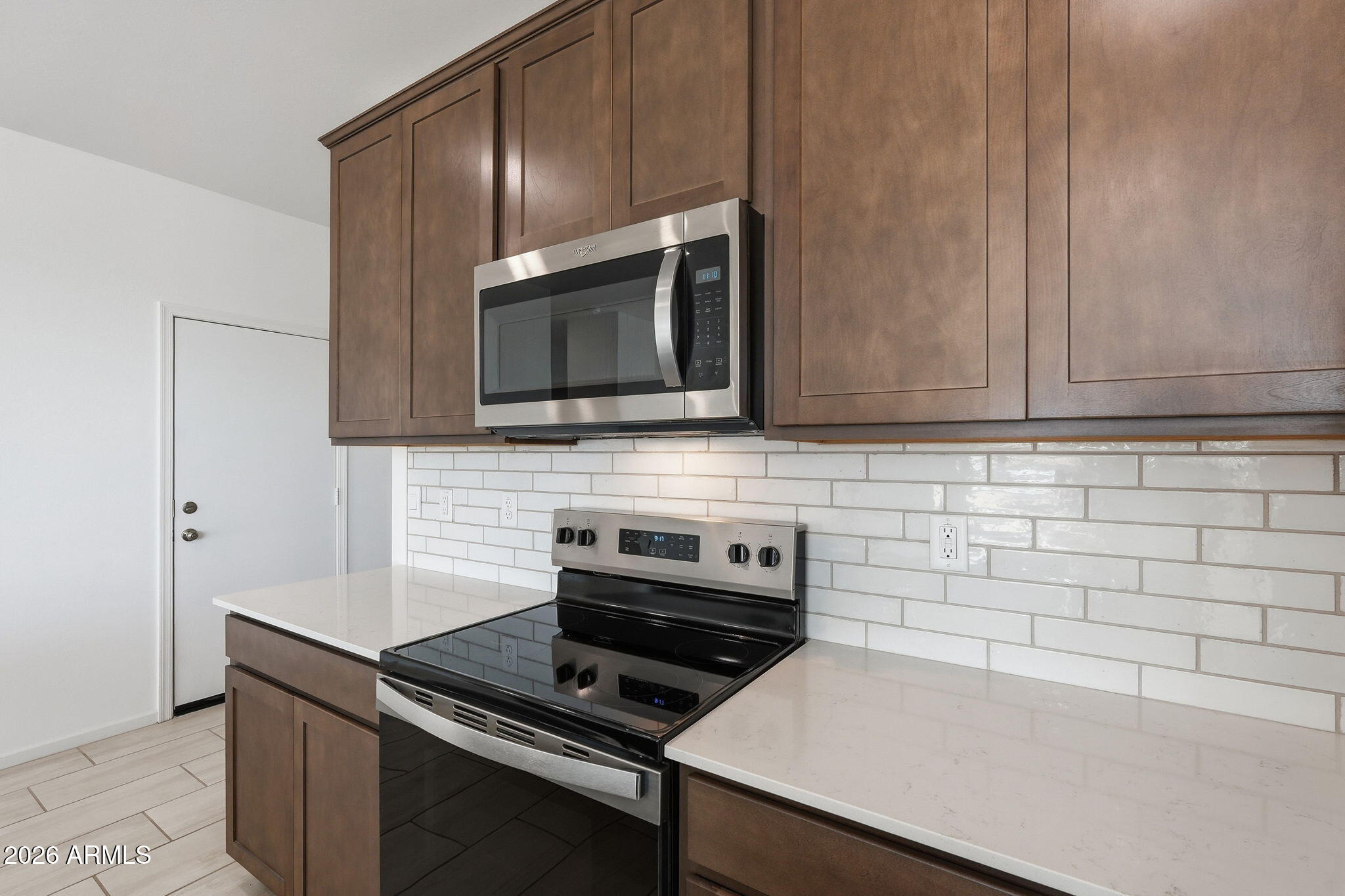 25489 West Fraktur Road Buckeye, AZ 85326 - Photo 13 of 39 a kitchen with granite countertop a stove and a microwave