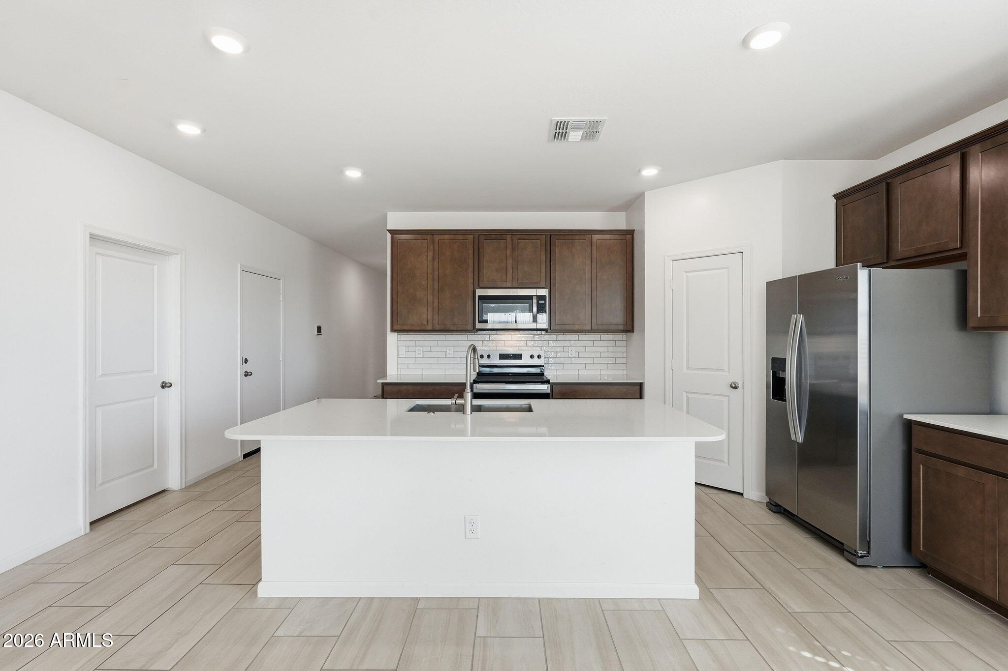25489 West Fraktur Road Buckeye, AZ 85326 - Photo 14 of 39 a kitchen with stainless steel appliances a refrigerator and a stove