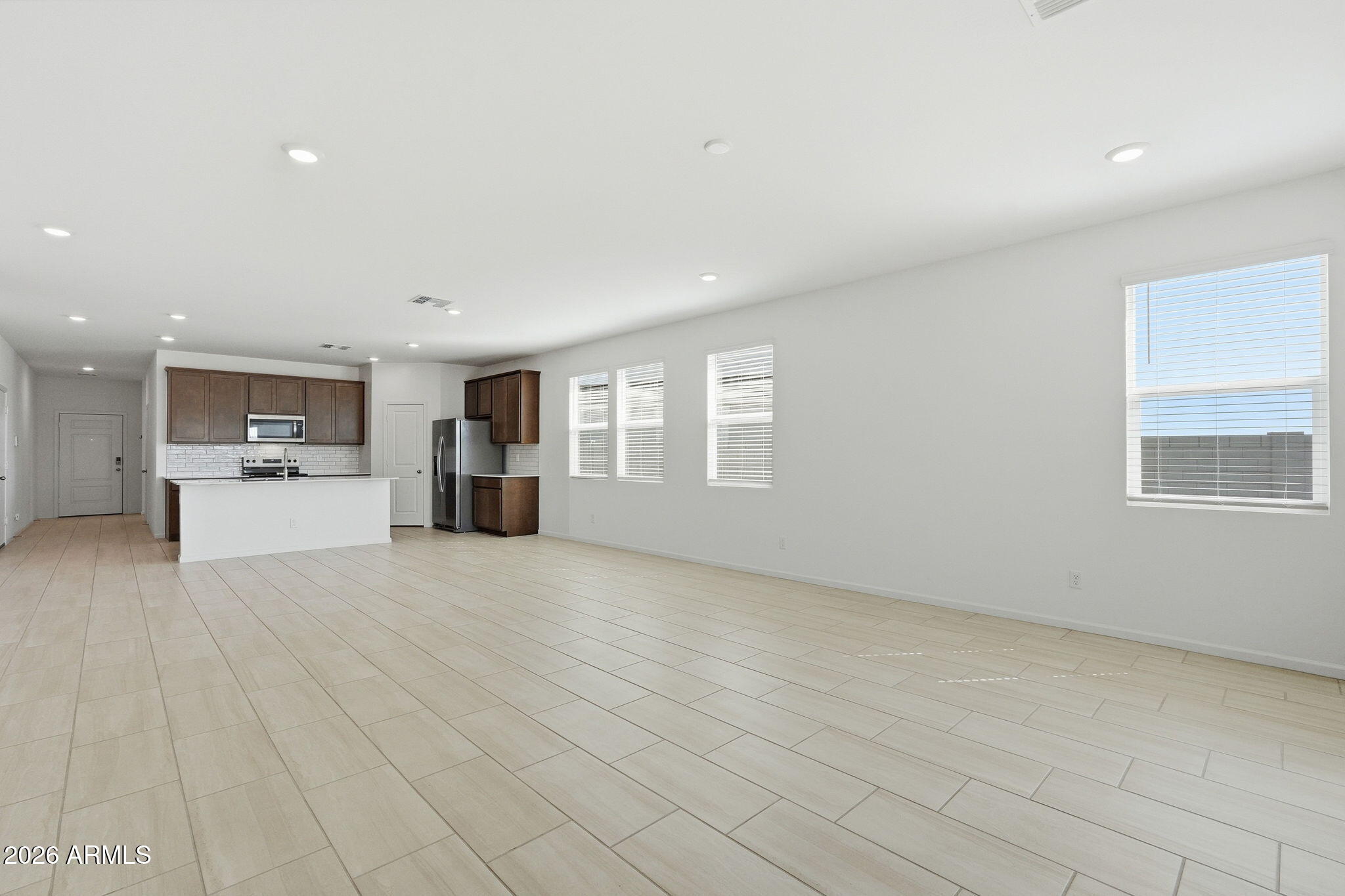 25489 West Fraktur Road Buckeye, AZ 85326 - Photo 19 of 39 a view of a kitchen with a sink and dishwasher a refrigerator with white cabinets