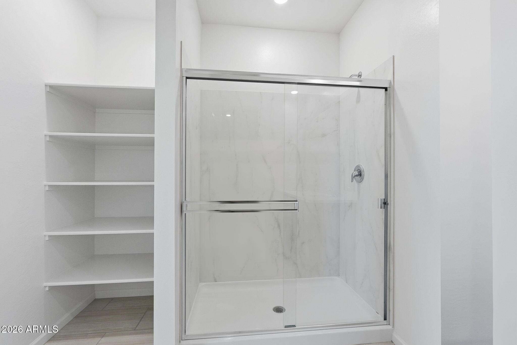 25489 West Fraktur Road Buckeye, AZ 85326 - Photo 26 of 39 a bathroom with a glass shower door