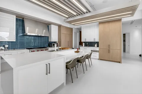 a large white kitchen with a stove a sink and a refrigerator