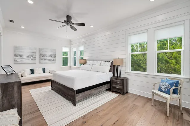 a bedroom with a bed wooden floor and window