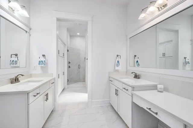 a large white bathroom with a double vanity sink a mirror and a bathtub