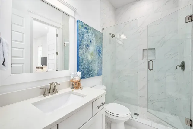 a bathroom with a sink toilet vanity and shower