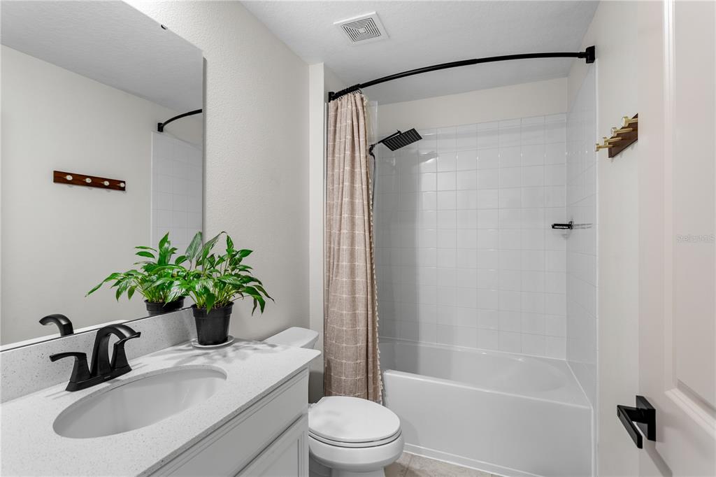 5693 Alenlon Way Mount Dora, FL 32757 - Photo 17 of 40 a bathroom with a sink a toilet a mirror and shower
