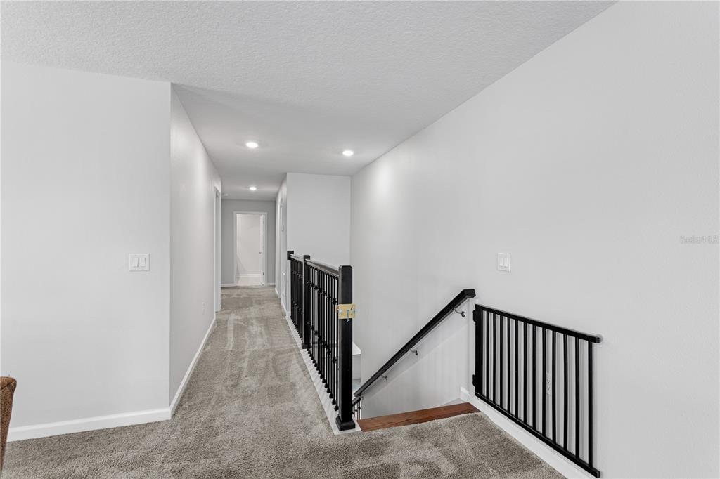 5693 Alenlon Way Mount Dora, FL 32757 - Photo 18 of 40 a view of a hallway with paintings on the wall