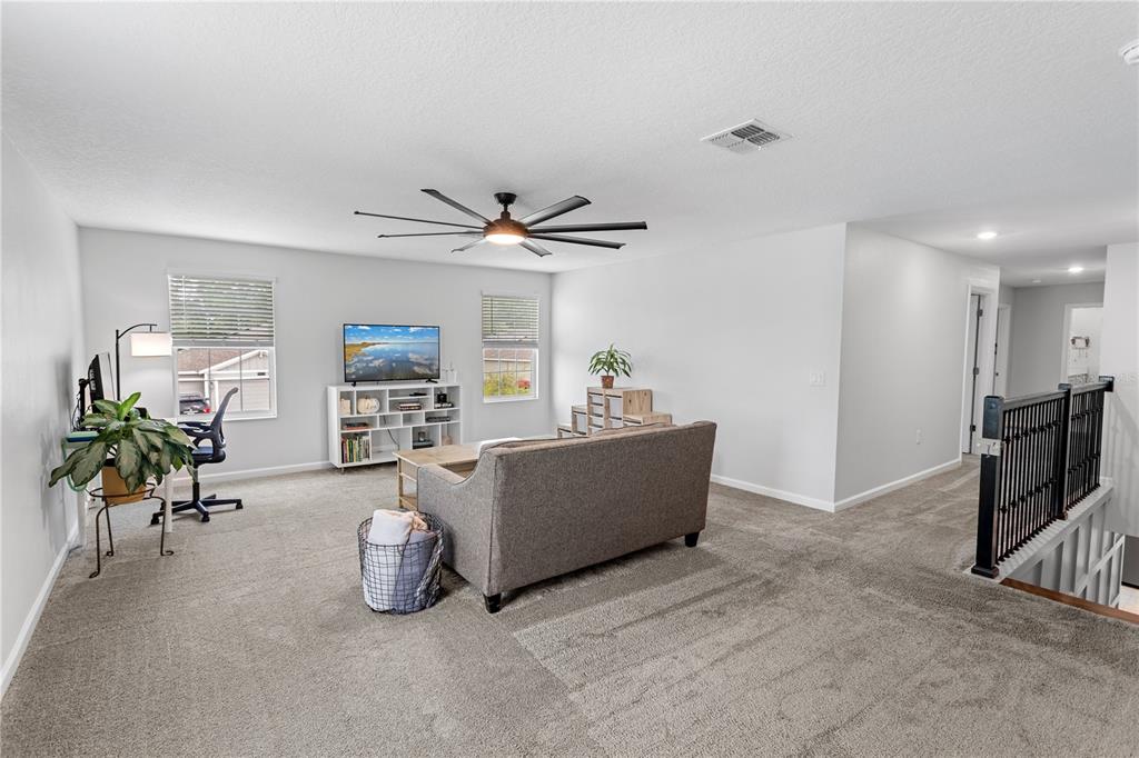 5693 Alenlon Way Mount Dora, FL 32757 - Photo 19 of 40 a living room with furniture and a flat screen tv