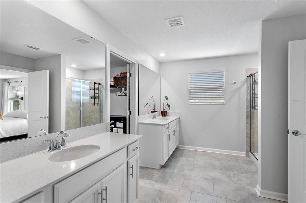 5693 Alenlon Way Mount Dora, FL 32757 - Photo 23 of 40 a bathroom with a sink vanity granite tub shower and a mirror