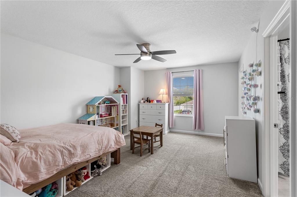5693 Alenlon Way Mount Dora, FL 32757 - Photo 27 of 40 a bedroom with a bed and a chandelier