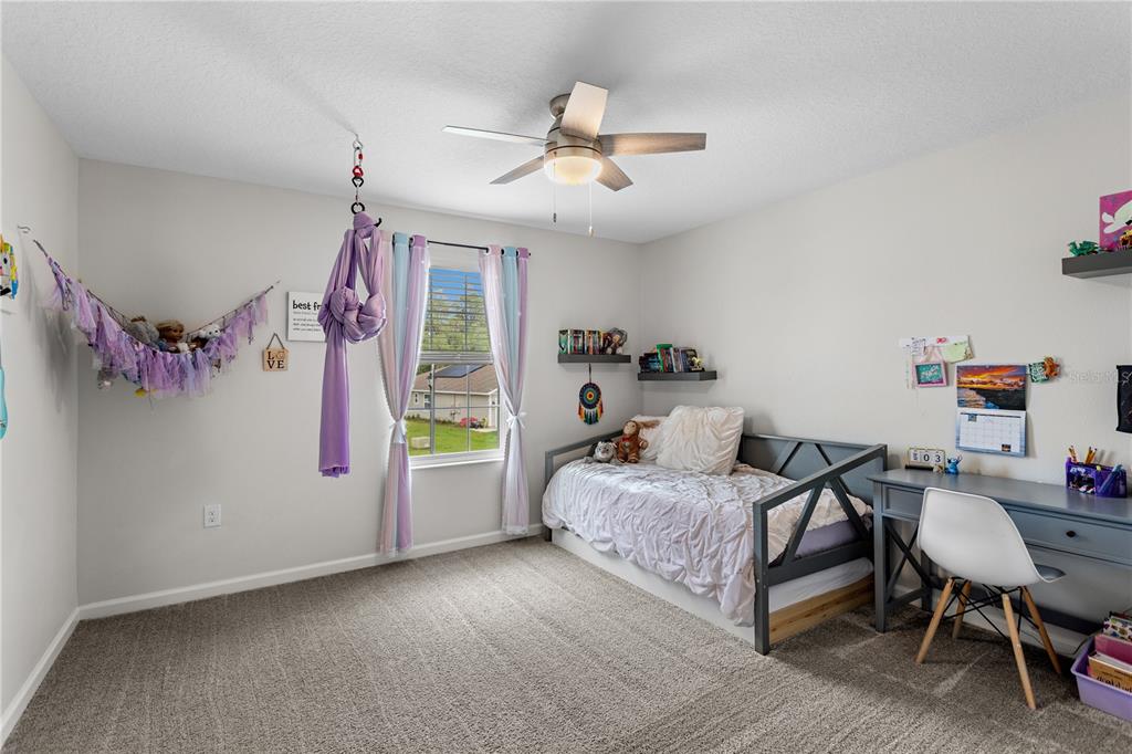 5693 Alenlon Way Mount Dora, FL 32757 - Photo 29 of 40 a bedroom with a bed and a chandelier