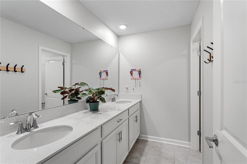 5693 Alenlon Way Mount Dora, FL 32757 - Photo 31 of 40 a bathroom with a double vanity sink and a mirror