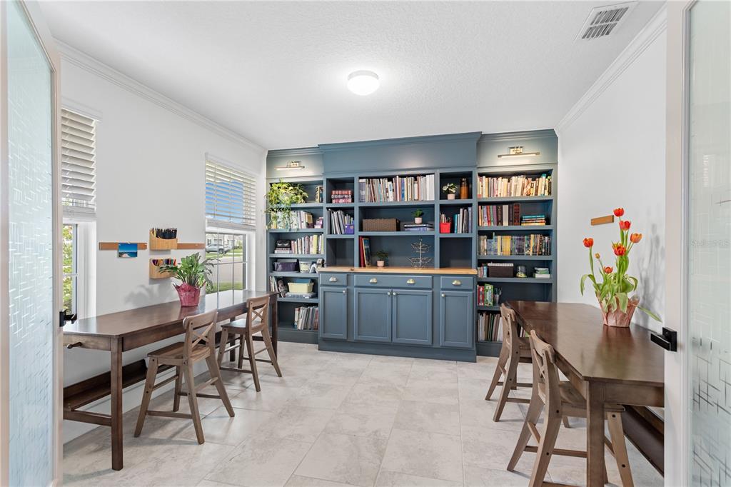 5693 Alenlon Way Mount Dora, FL 32757 - Photo 5 of 40 a view of a workspace with furniture and a bookshelf