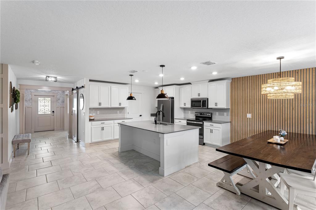 5693 Alenlon Way Mount Dora, FL 32757 - Photo 7 of 40 a kitchen with stainless steel appliances kitchen island granite countertop a sink and cabinets
